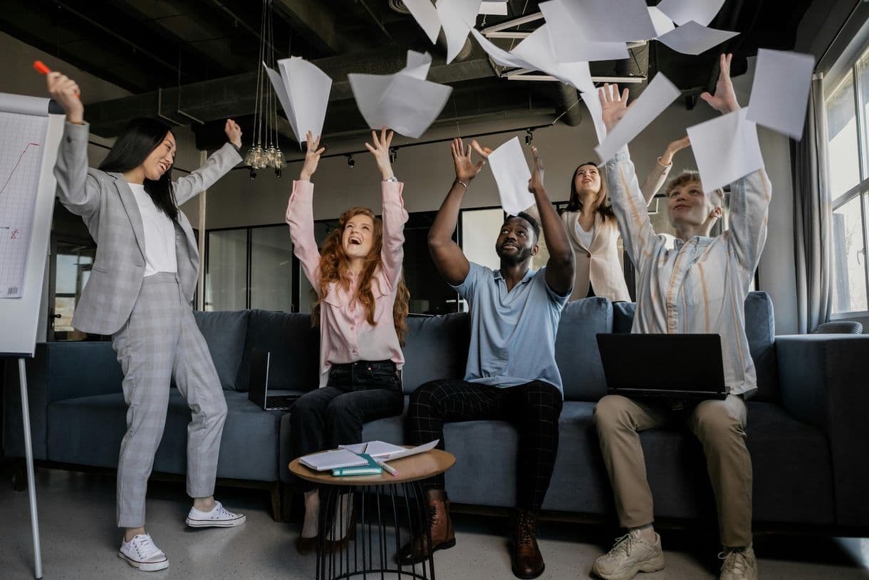 team members throwing papers up and laughing